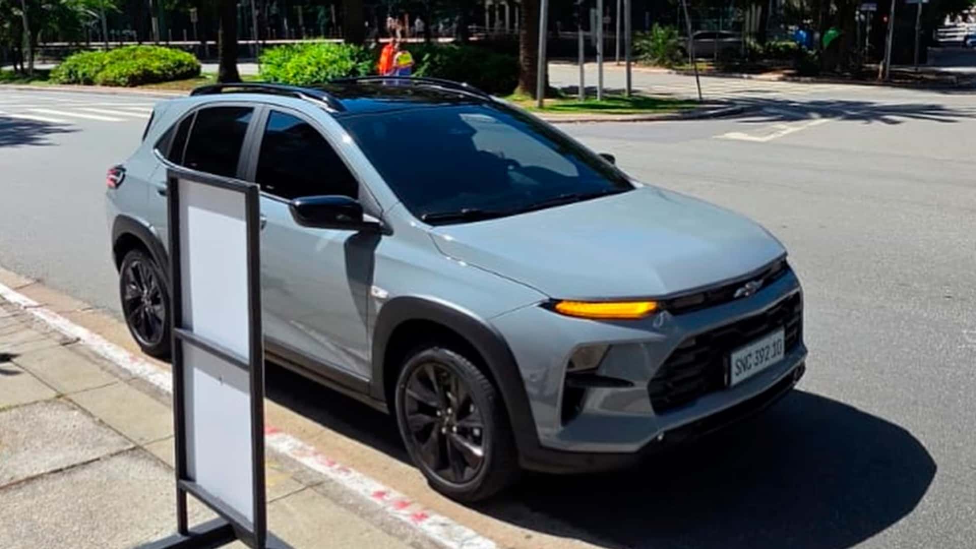 SUV Chevrolet em uma rua arborizada, destacando seu design moderno e detalhes em vermelho na iluminação frontal.